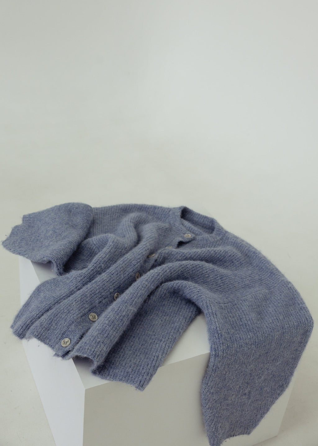 Blue knitted scarf on a mannequin against a white background