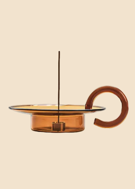 Amber-colored glass teapot with a handle on a white background