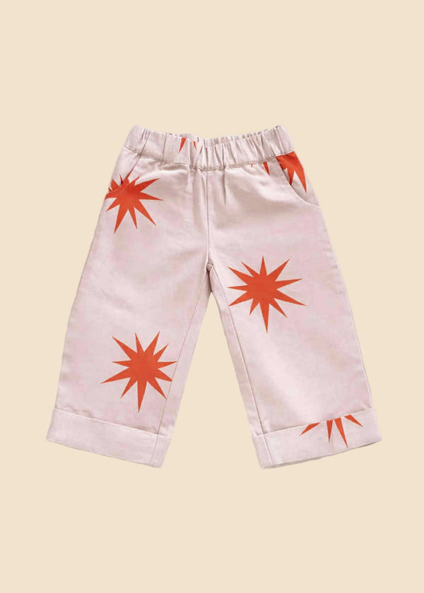 Pink pants with orange starburst patterns on a white background