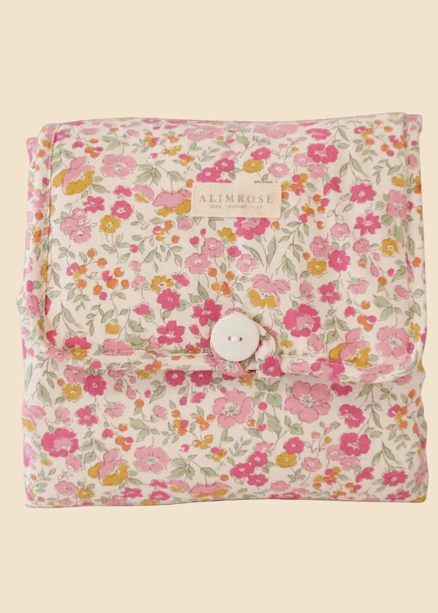 Floral-patterned fabric with a button closure on a white background