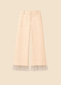 Beige pants with lace trim on a light pink background