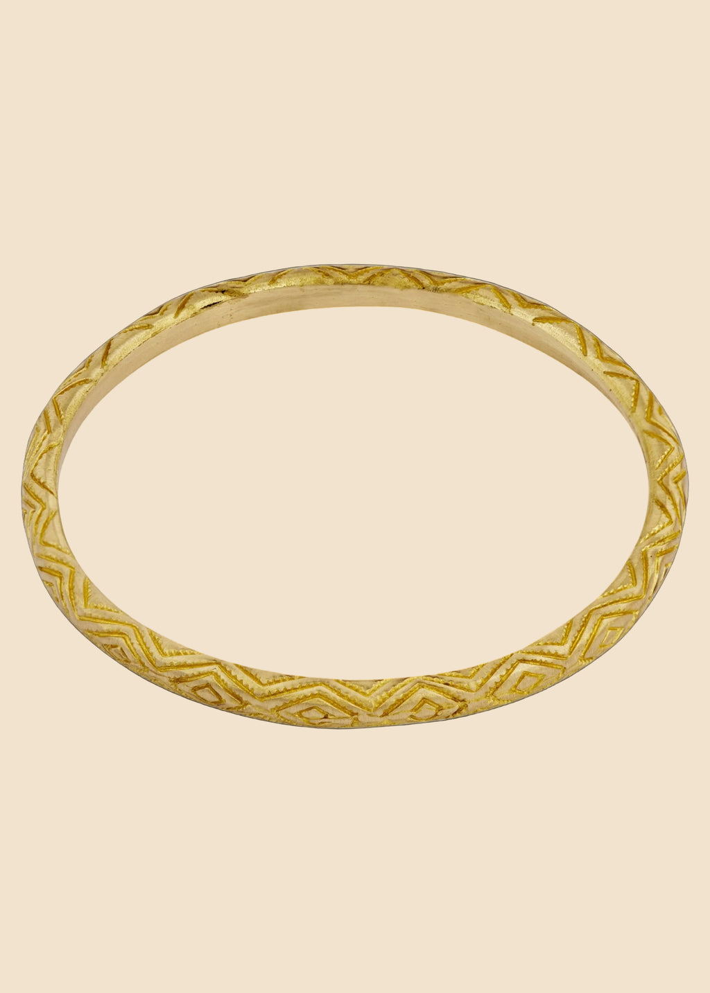 Gold bracelet with intricate design on a white background