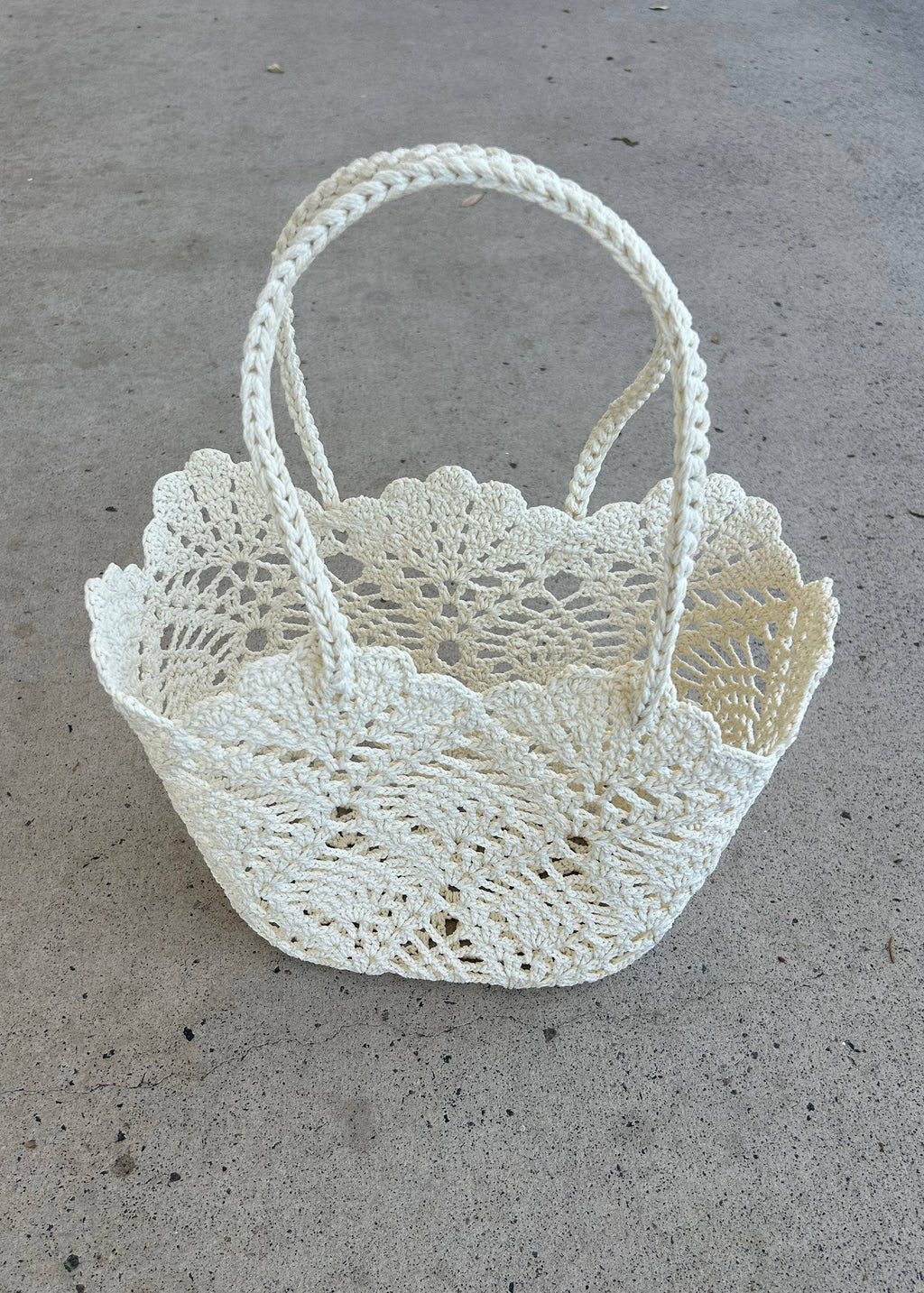 White crochet basket on a concrete surface