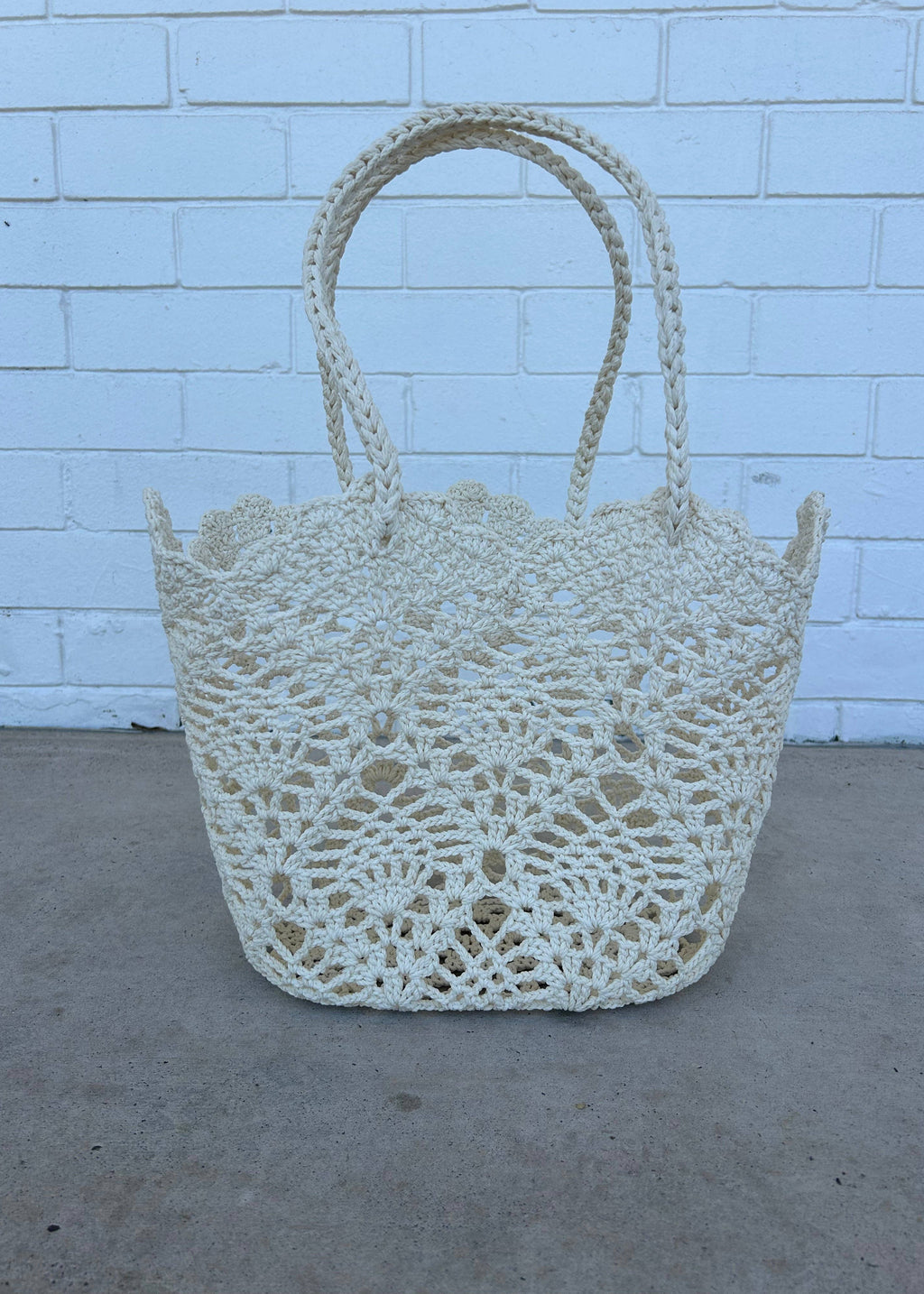 Crocheted basket against a light blue brick wall