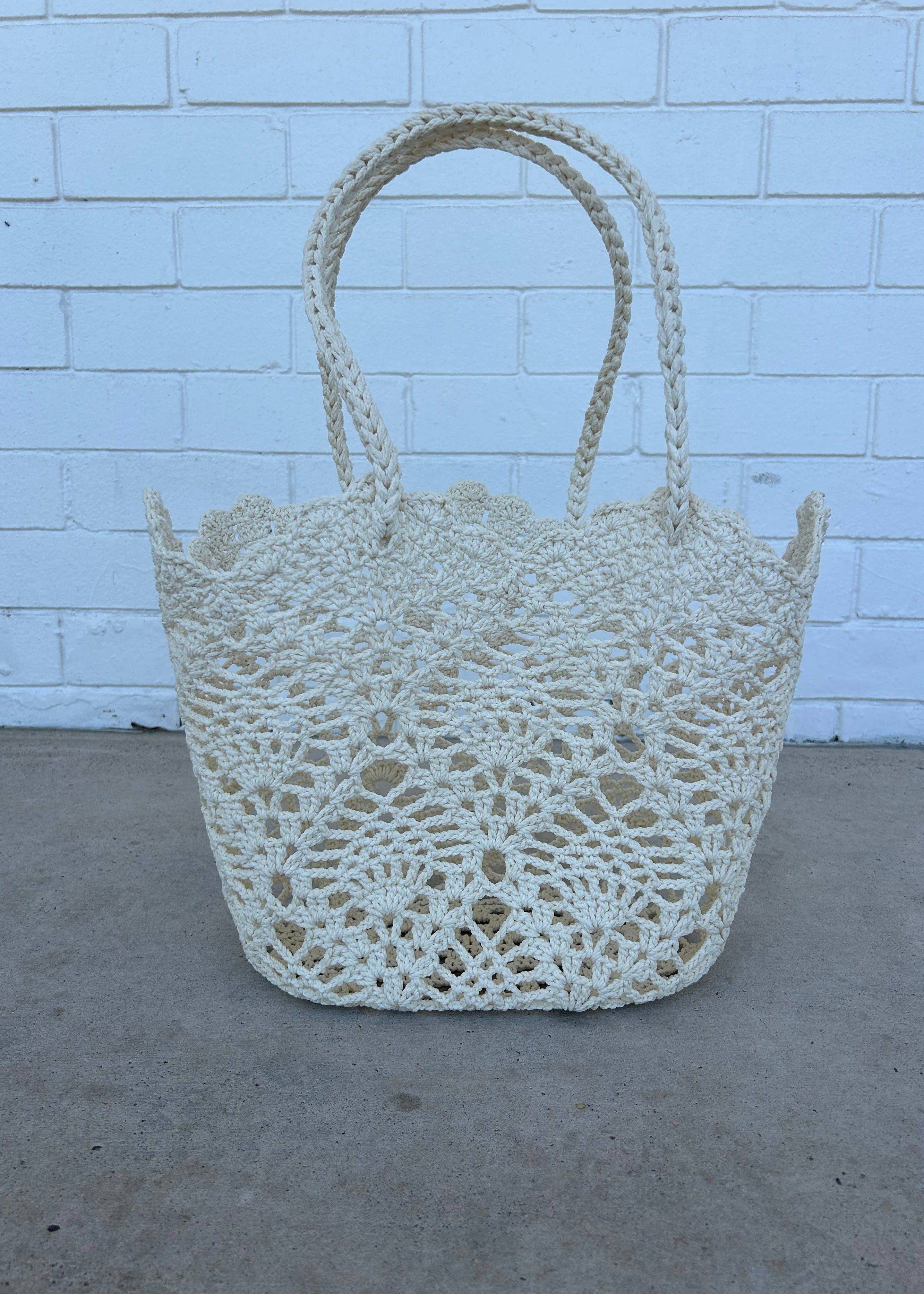 Crocheted basket against a light blue brick wall