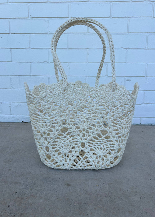 Crocheted basket against a light blue brick wall