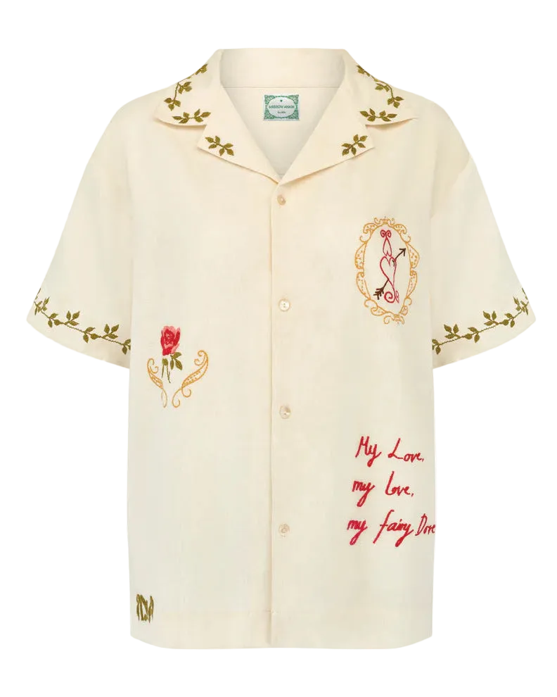 Beige shirt with floral embroidery and text on a white background
