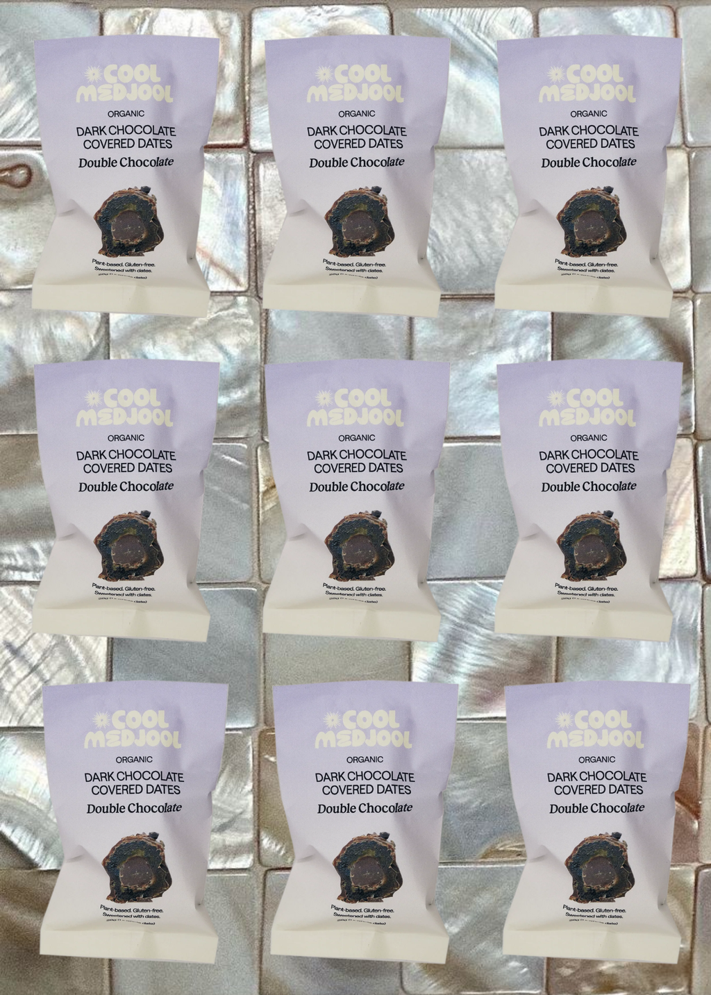 Grid of packages of 'Double Chocolate' dark chocolate covered dates on a reflective surface.