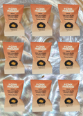 Multiple packages of 'A Cool Medjool' dark chocolate covered dates with peanut butter on a reflective surface.