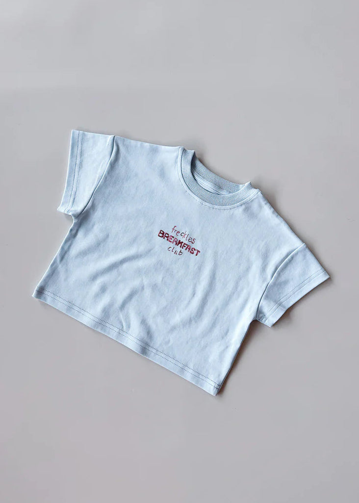 Light blue t-shirt with text on a gray background