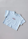 Light blue t-shirt with text on a gray background