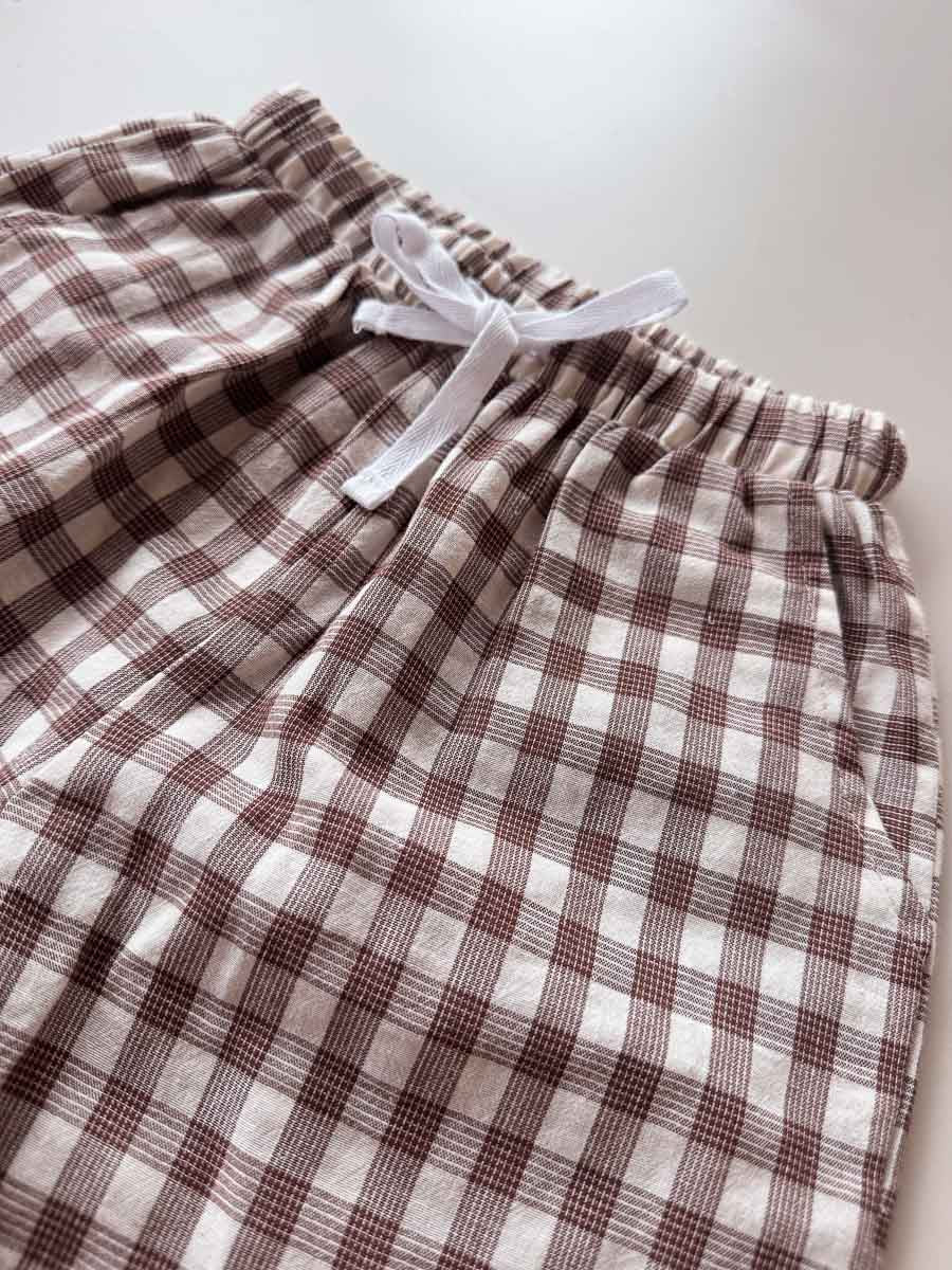 Plaid shorts with a white drawstring on a light background