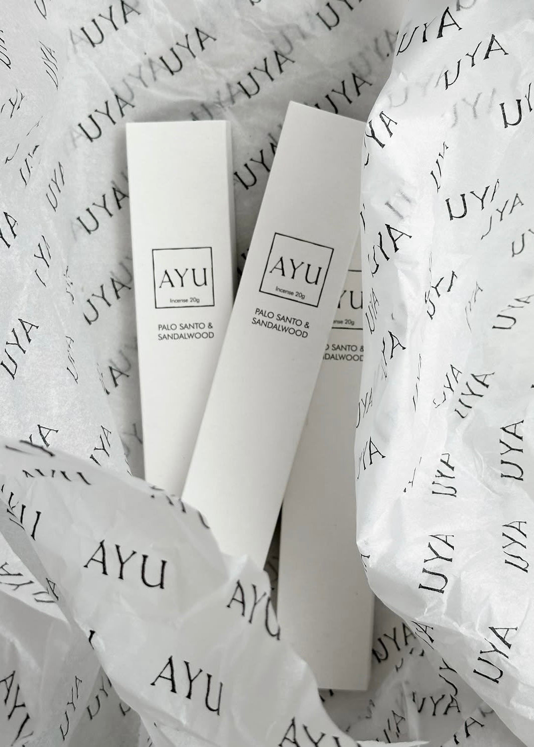 AYU skincare products on a branded paper background
