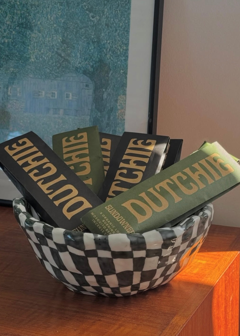 Bowl filled with 'Dutchie' incense cases on a wooden surface