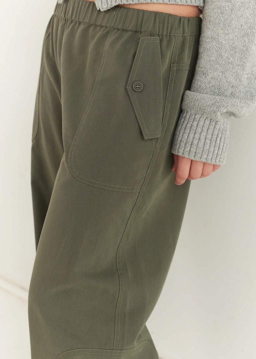 Green pants with a pocket detail on a white background