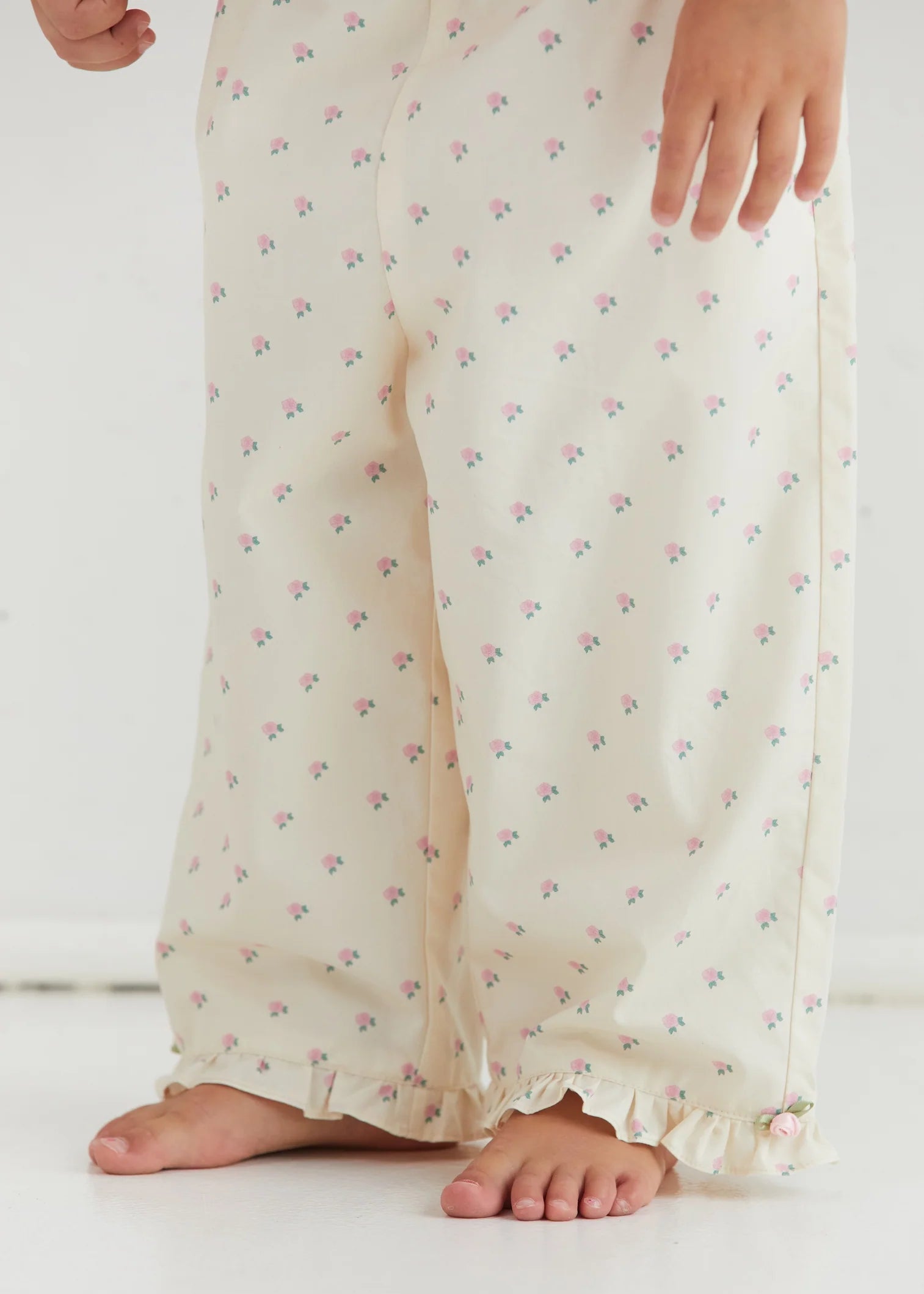 White floral pajama pants worn by a person on a white background
