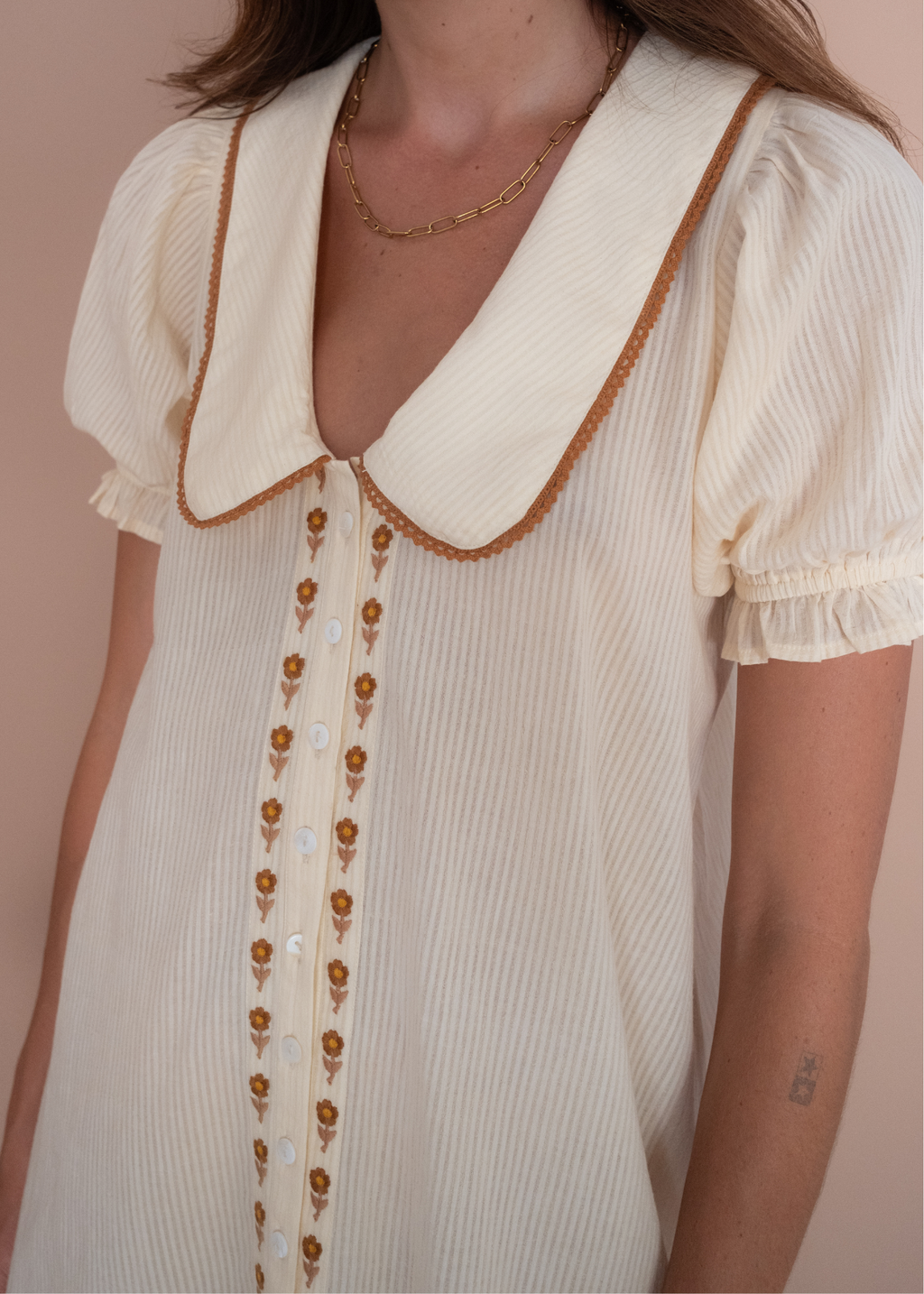 Close-up of a person wearing a vintage-style blouse with a collar and buttons.