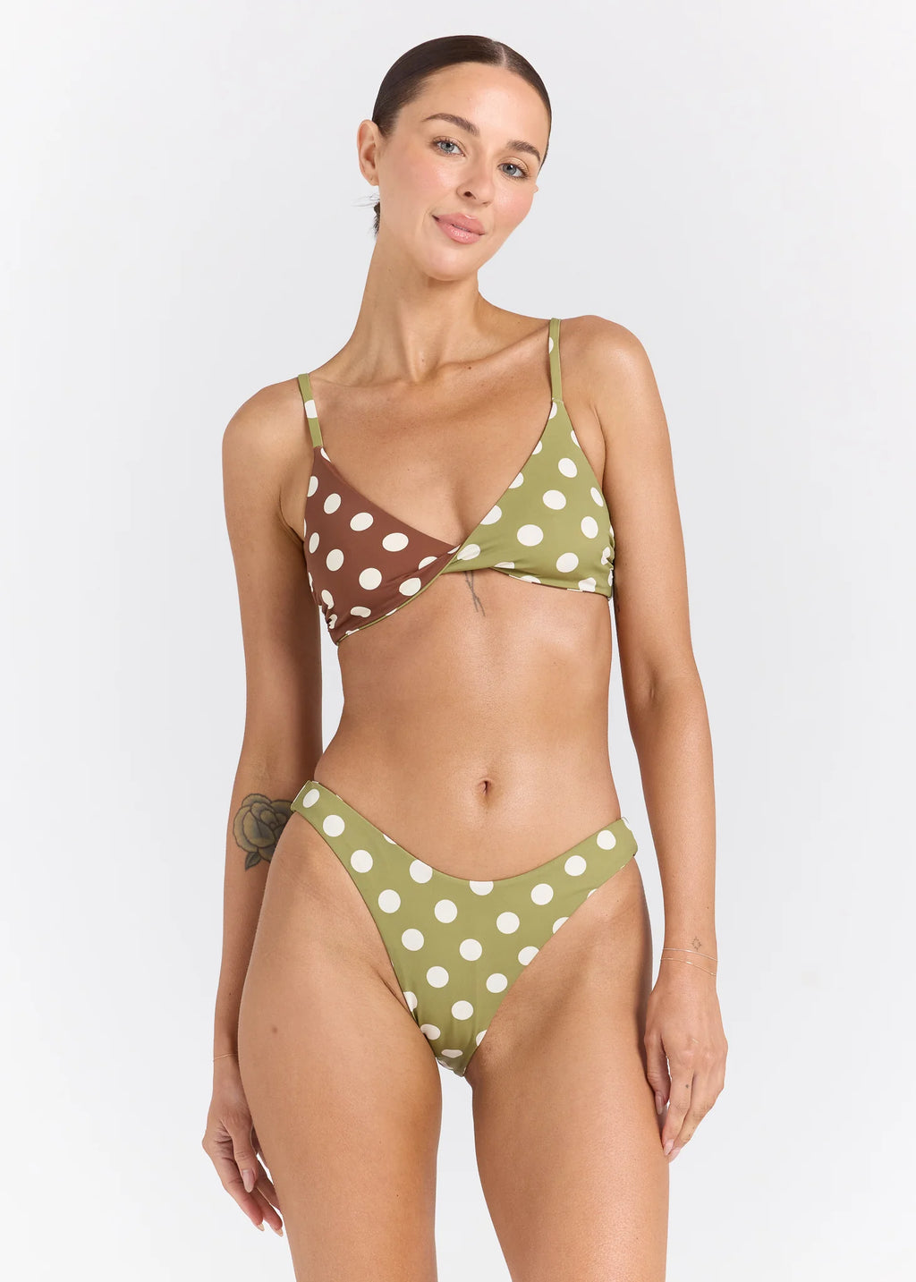 Woman wearing a polka dot bikini set on a white background