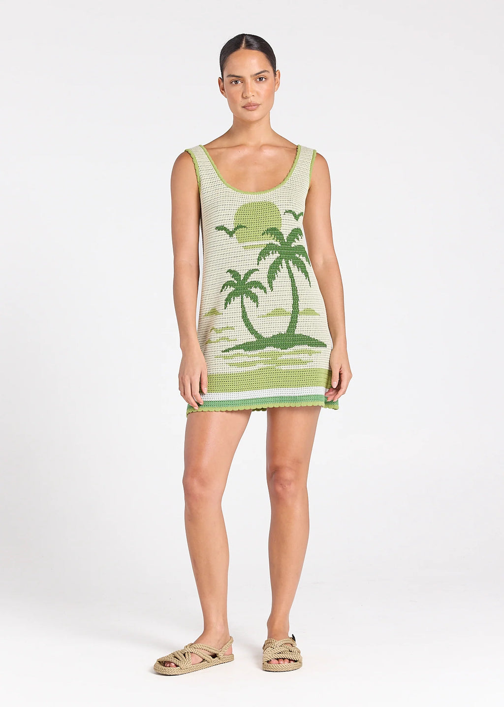 Woman wearing a green dress with palm tree design on a white background