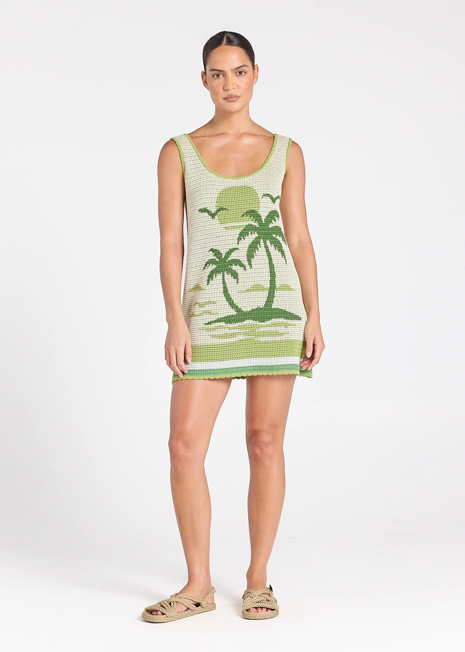 Woman wearing a green dress with palm tree design on a white background
