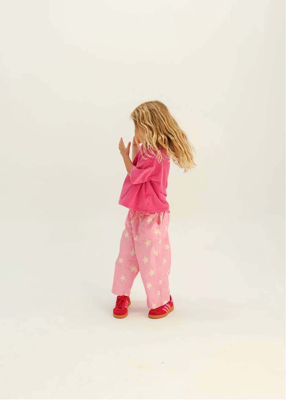 Child wearing pink pajamas with a white background