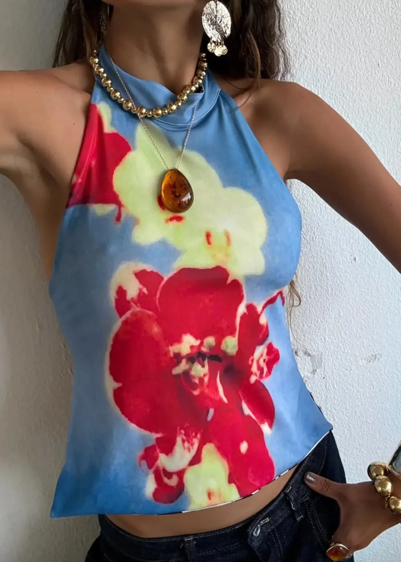 Woman wearing a colorful floral top with a plain background