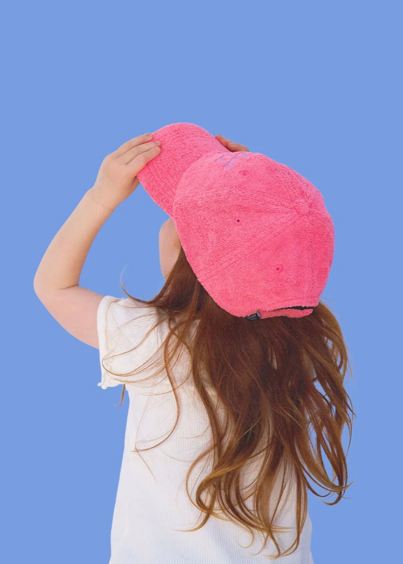 Person wearing a pink cap against a blue background