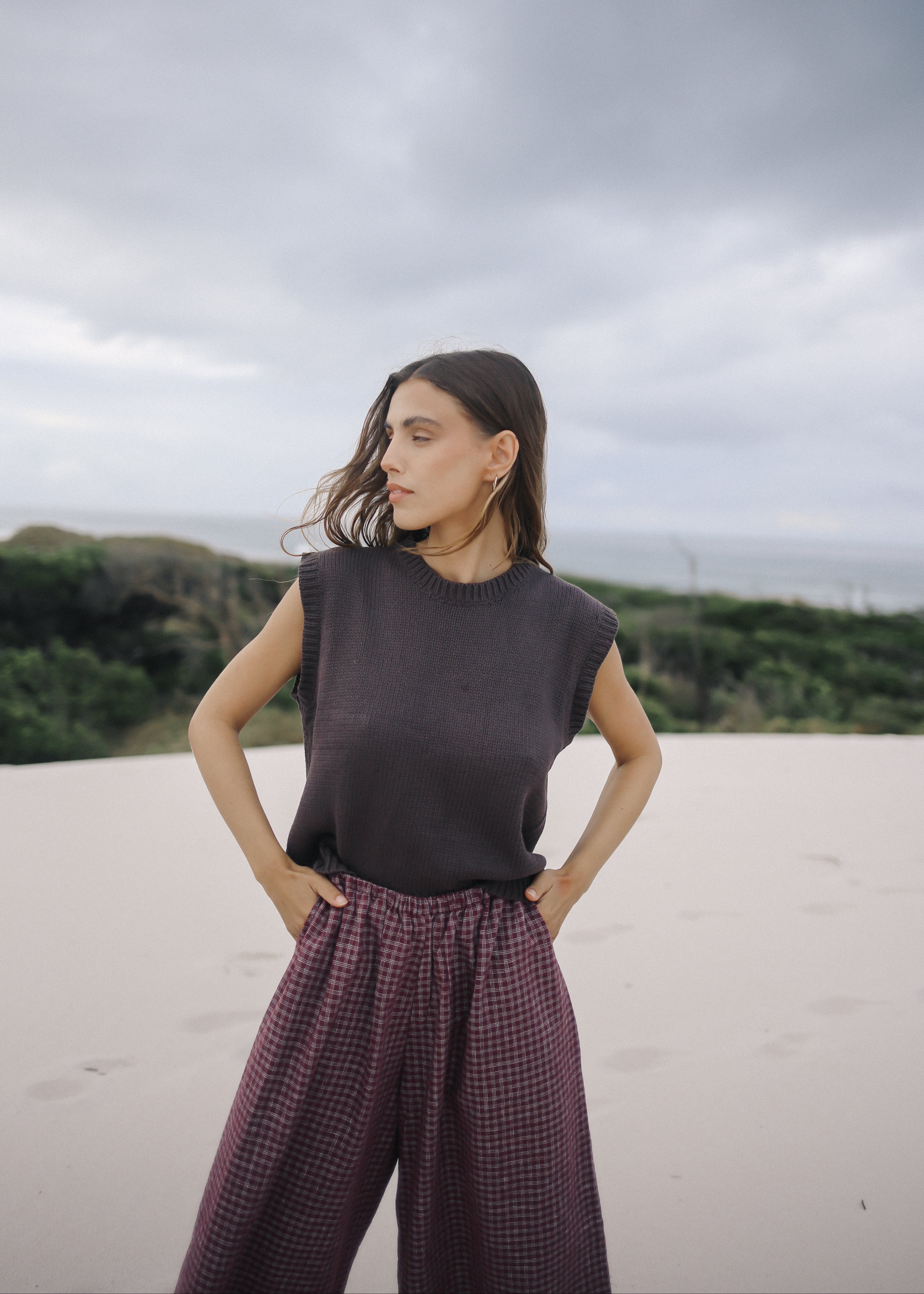 Woman standing on a beach with a cloudy sky
