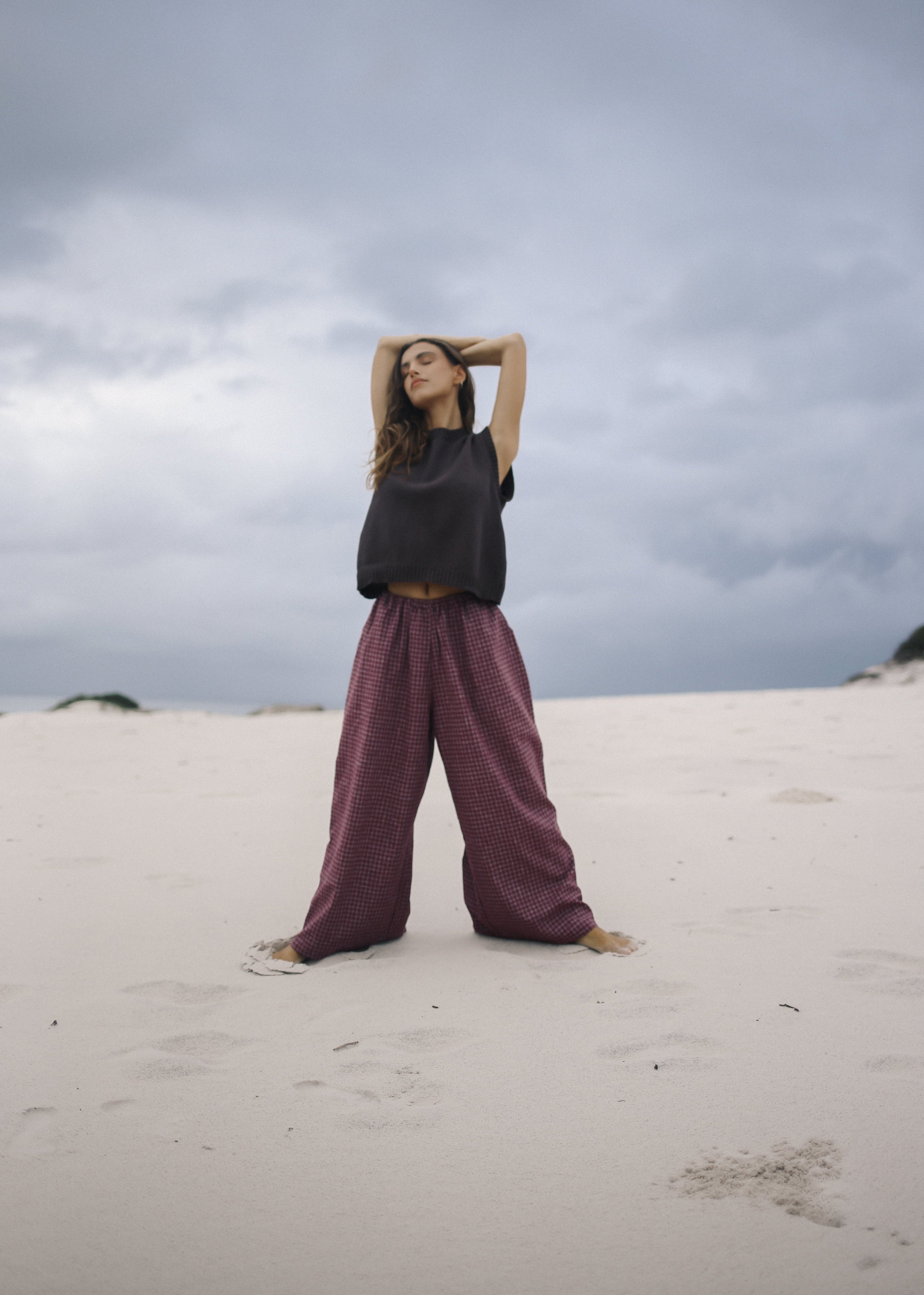 Person standing on a sandy dune with a cloudy sky