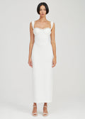 A woman modeling a white sleeveless midi dress with a structured sweetheart neckline, ruffled shoulder straps, and a fitted silhouette, photographed against a light gray studio background.