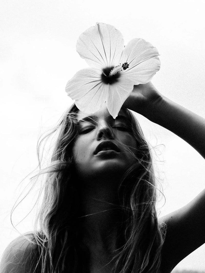 Black and white photo of a woman with a flower on her head