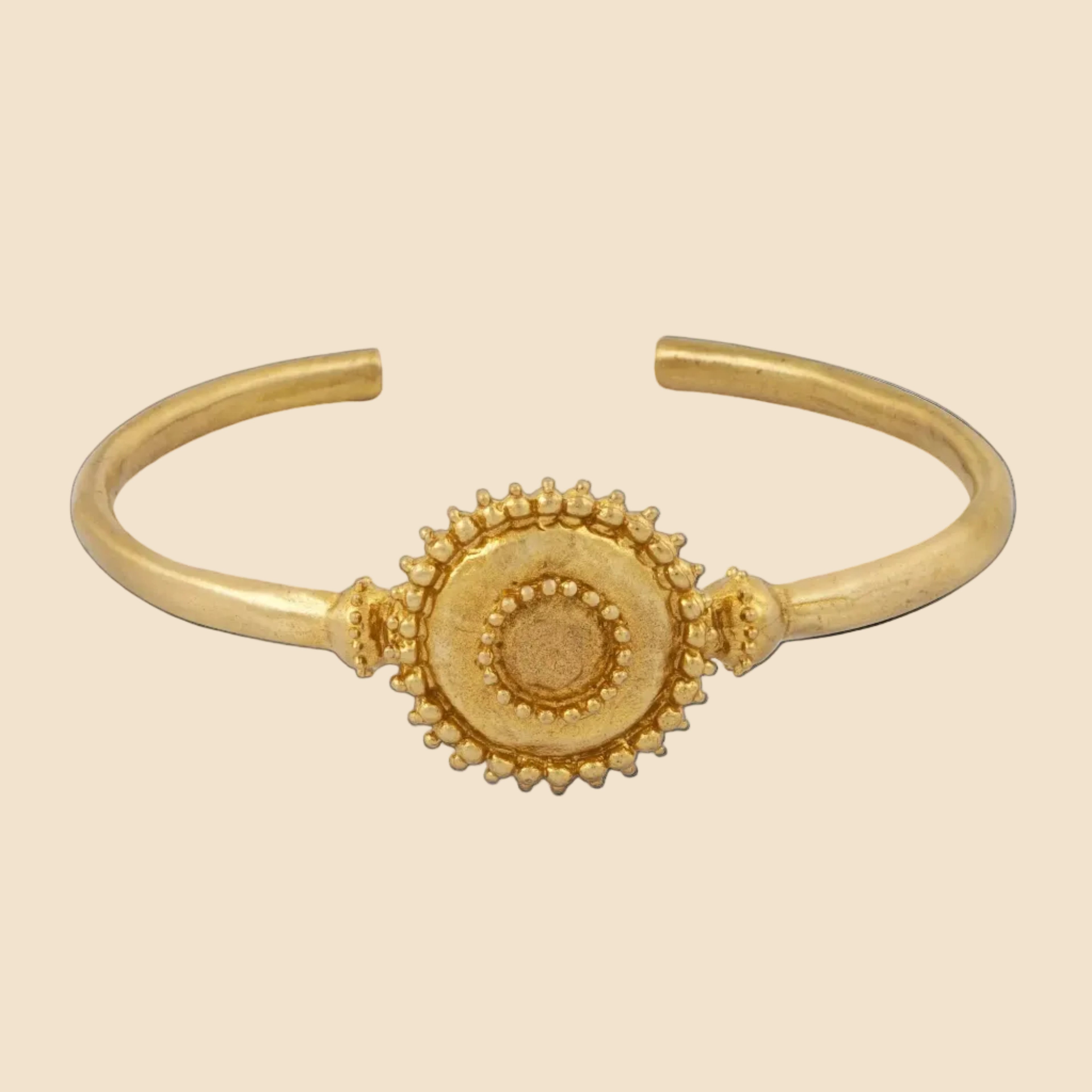Gold bracelet with a circular design on a white background