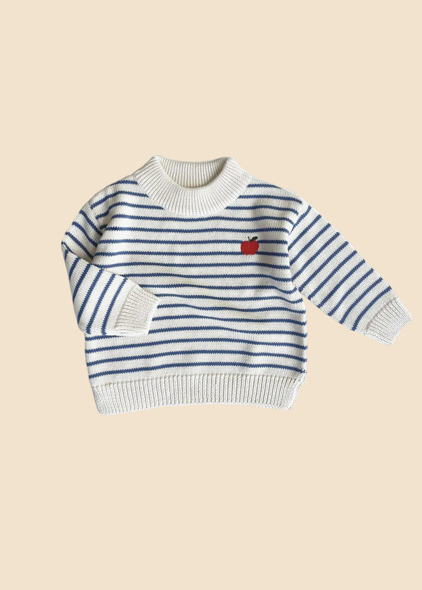 Striped sweater with a red apple design on a white background