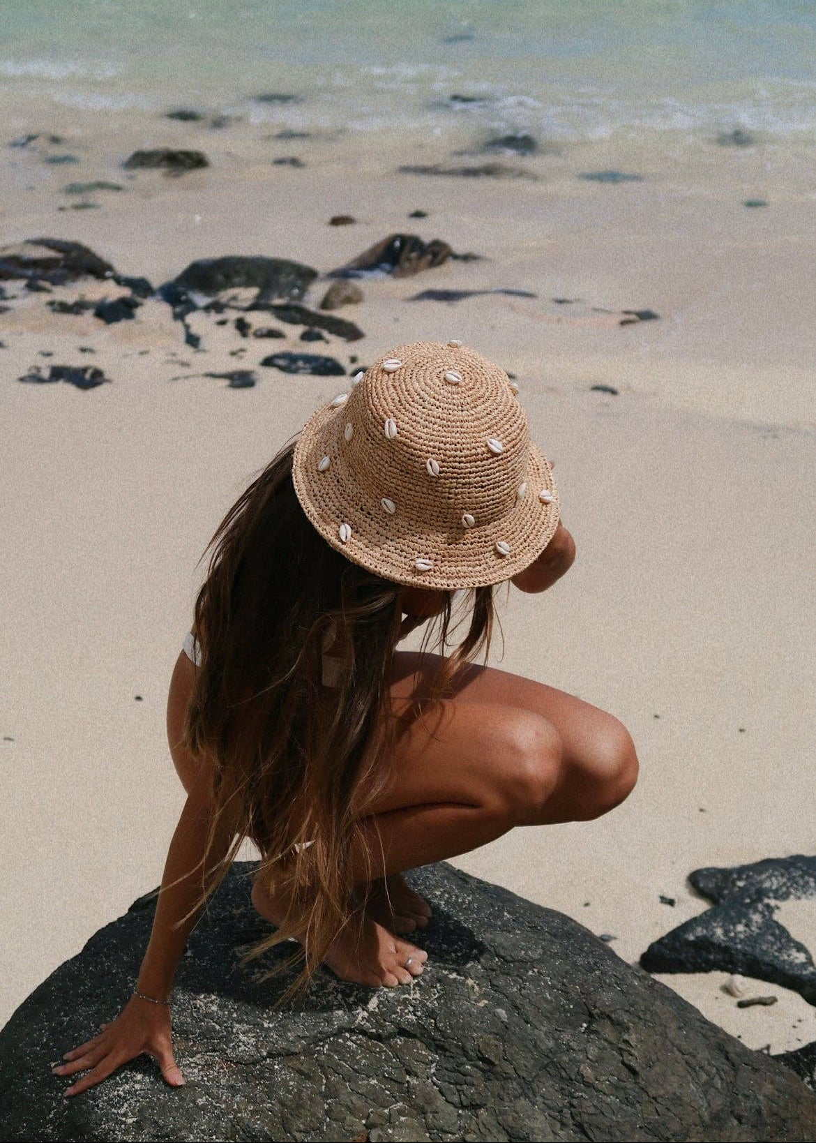Person wearing a straw hat on a beach